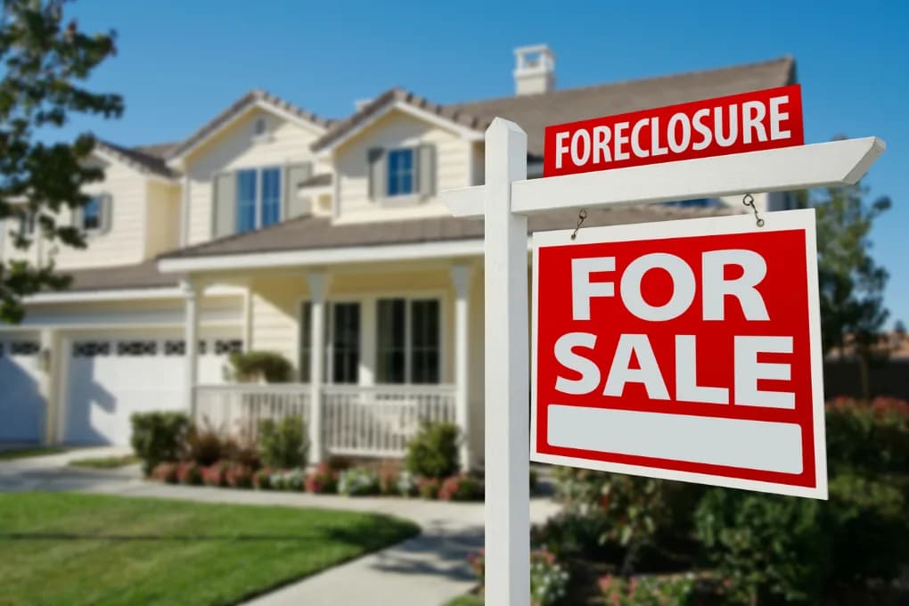 House with a foreclosure for sale sign in the front yard.