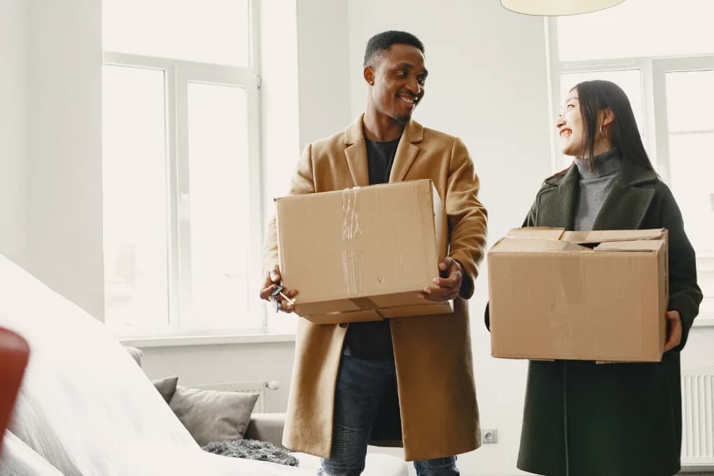 Man and woman holding moving boxes.