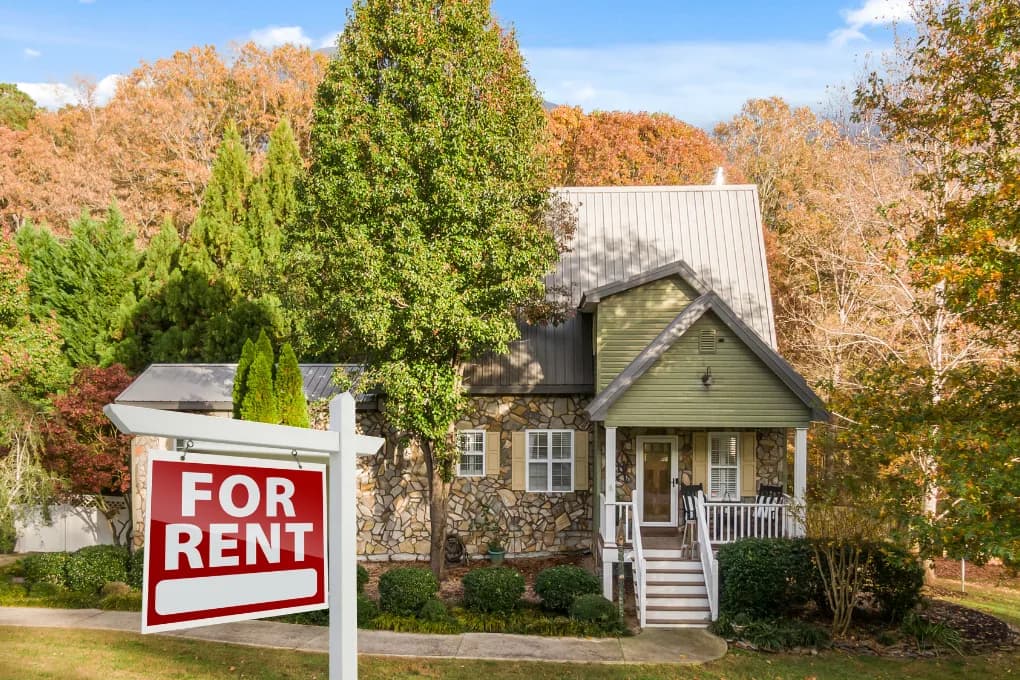 House with for rent sign in front yard.