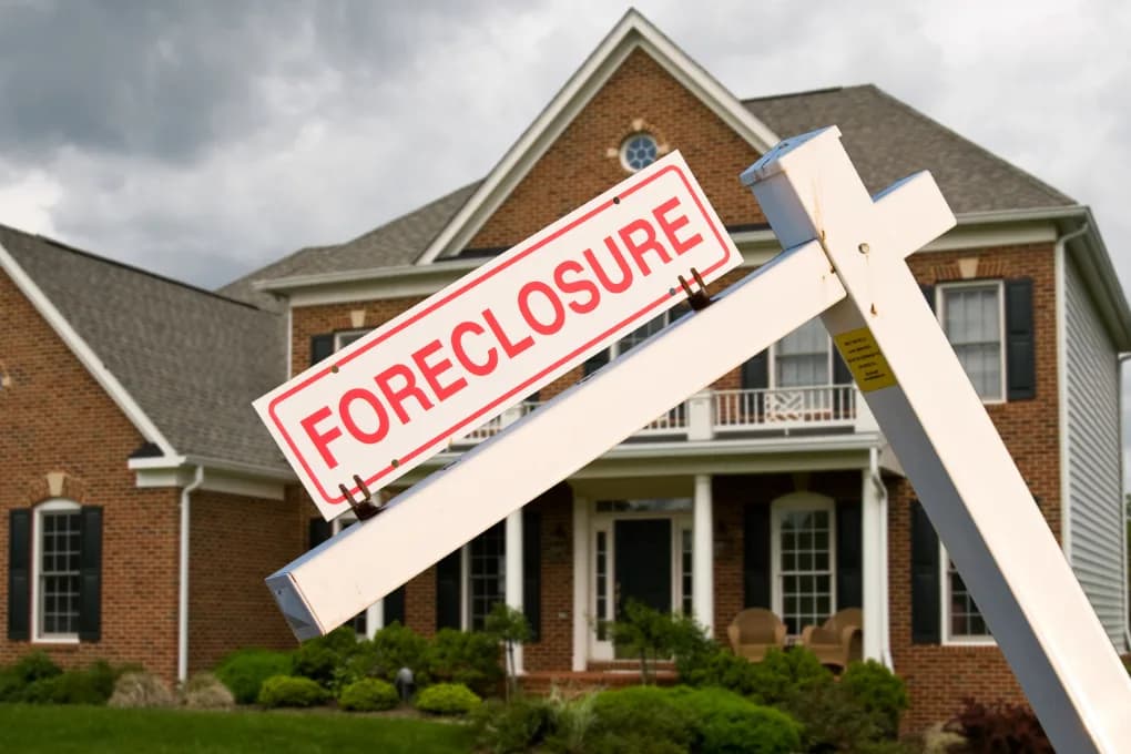 House with a foreclosure sign in the front yard.