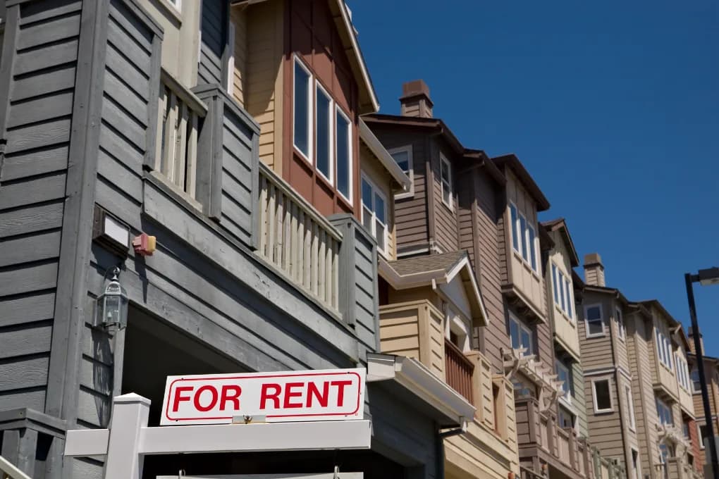 Townhouse with a "for rent" sign in the front.